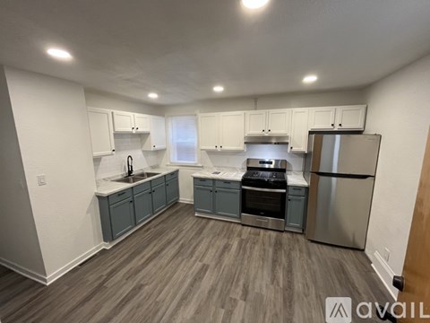 A kitchen with a refrigerator, stove, and sink.