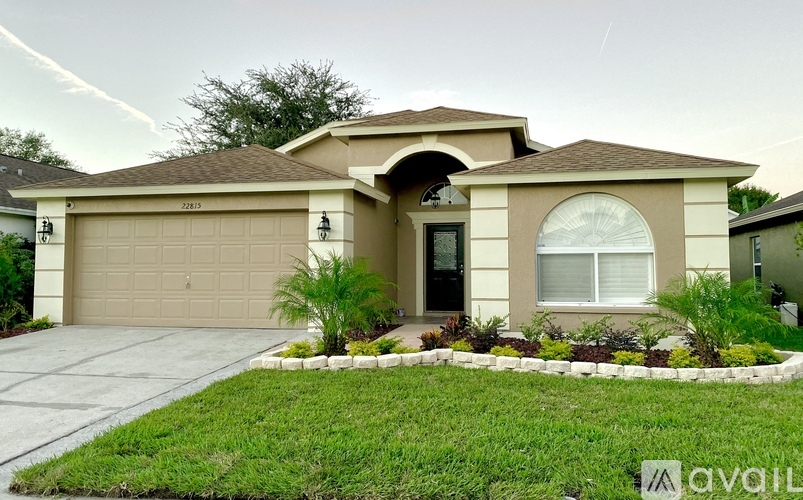 A house with a garage and a driveway in front of it.