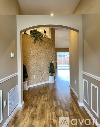 A hallway with a stone wall and wooden floors.