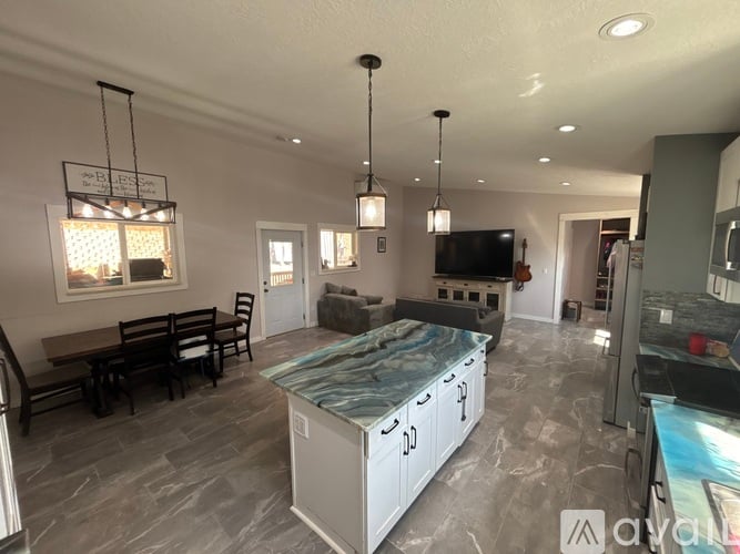 A spacious kitchen with a dining table and chairs.