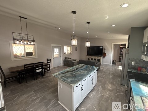 A spacious kitchen with a dining table and chairs.