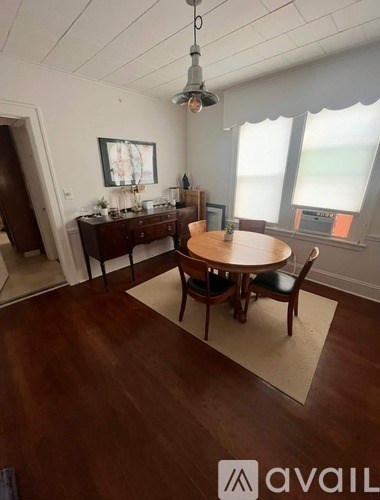 A dining room with a wooden table and chairs.