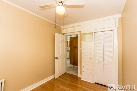 A room with a ceiling fan and a door leading to another room.