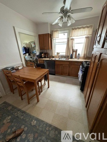 A kitchen with a table and chairs in front of a window.
