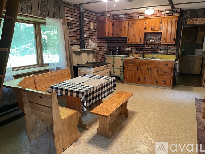 A kitchen with wooden cabinets and a checkered tablecloth.