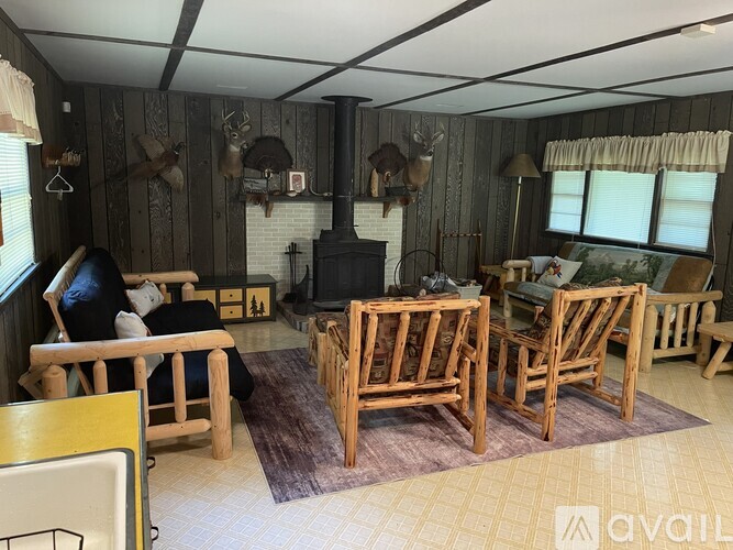 A living room with a fireplace and wooden furniture.