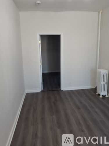 A room with a grey floor and a white radiator.