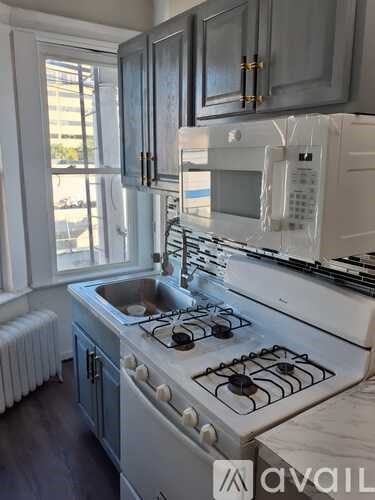 A kitchen with a white stove top oven and a white microwave above it.
