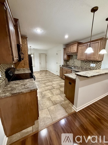 A kitchen with brown cabinets and a granite countertop.