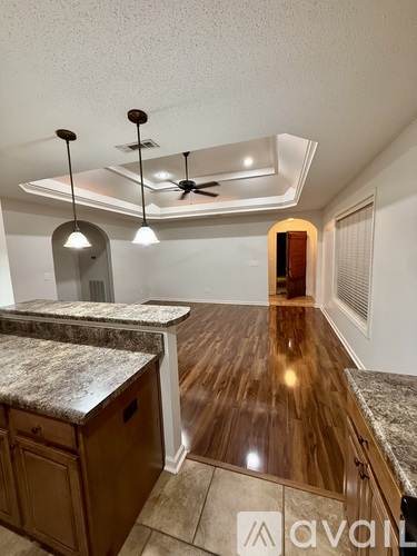A kitchen with wooden floors and a marble countertop.