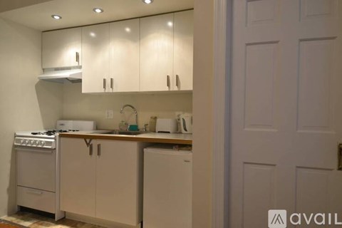 A kitchen with white appliances and cabinets.
