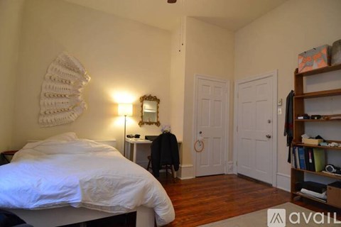 A bedroom with a bed, a dresser, a mirror, and a bookshelf.