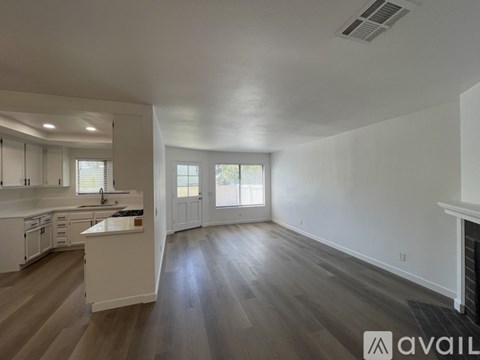 A spacious living room with a fireplace and hardwood floors.