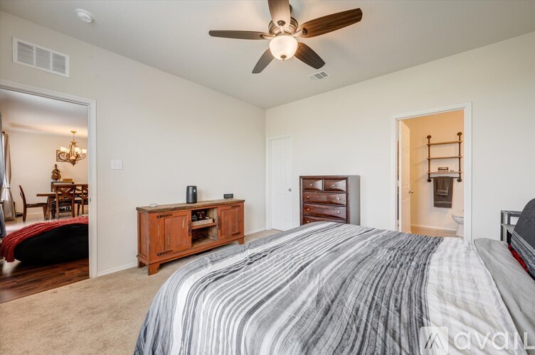 A bedroom with a large bed and a ceiling fan.