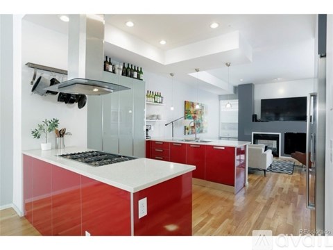 A modern kitchen with red cabinets and a white countertop.