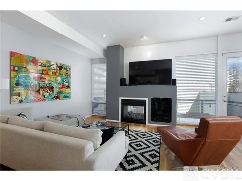 A living room with a large painting on the wall and a fireplace.