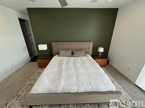 A bedroom with a large bed and a ceiling fan.