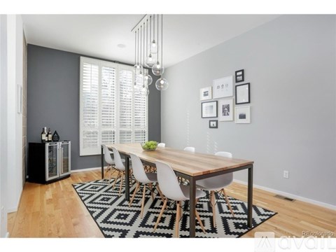 A dining room with a wooden table and white chairs.