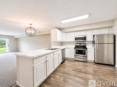 A modern kitchen with white cabinets and stainless steel appliances.