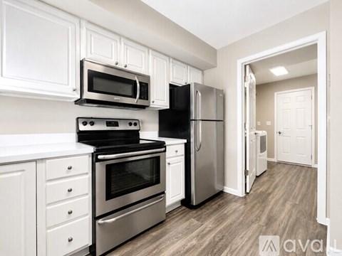 A kitchen with white cabinets and stainless steel appliances.