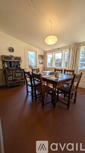 A dining room with a table and chairs.