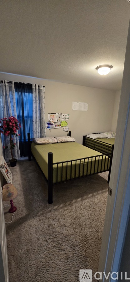 A bedroom with a bed and a window with curtains.