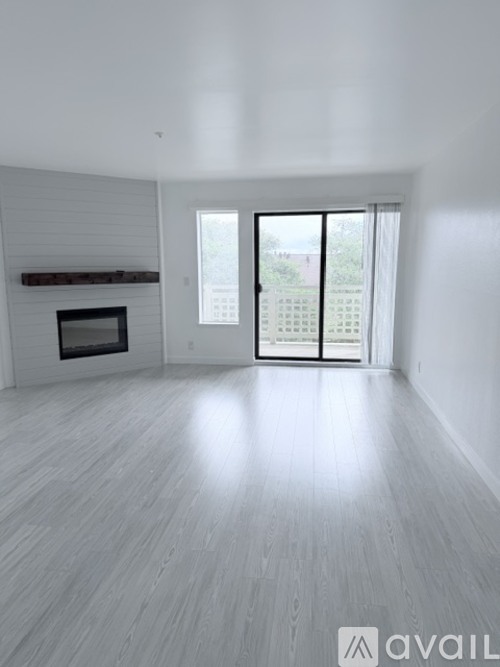 A spacious room with a fireplace and sliding glass doors.