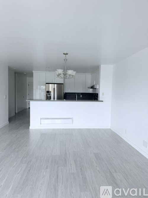 A spacious kitchen with a bar counter and a chandelier.