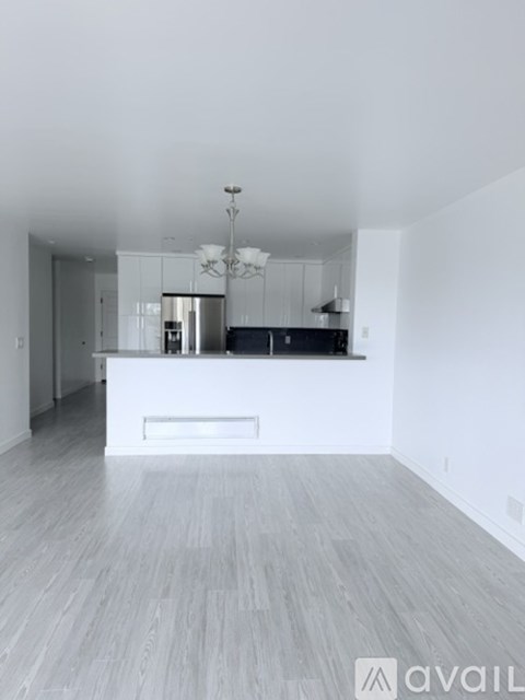 A spacious kitchen with a bar counter and a chandelier.