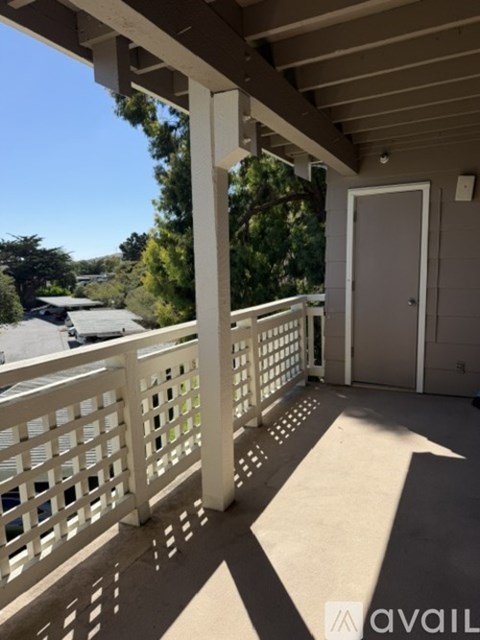 A balcony with a white railing and a door.