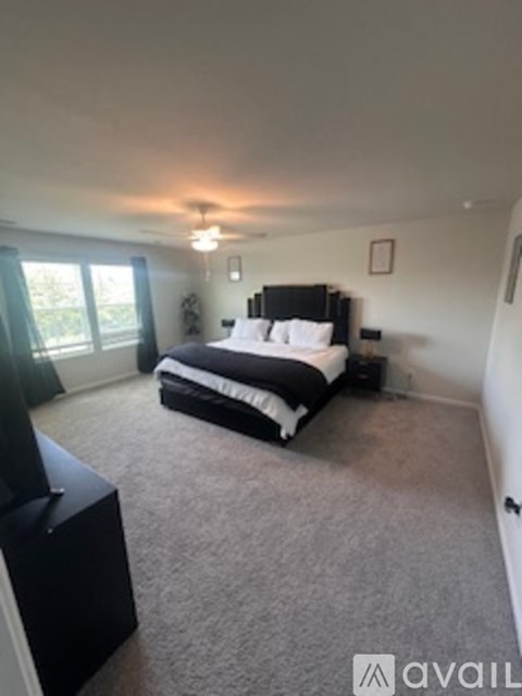 A bedroom with a large bed and a flat screen TV.