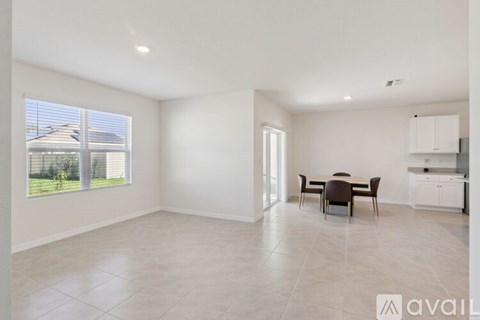 A spacious room with a dining table and chairs.