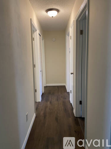 A hallway with wood floors and white walls.
