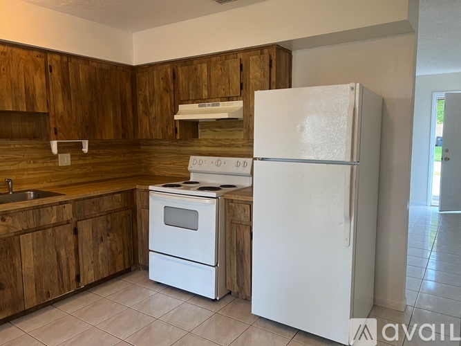 A kitchen with wooden cabinets and a white refrigerator.