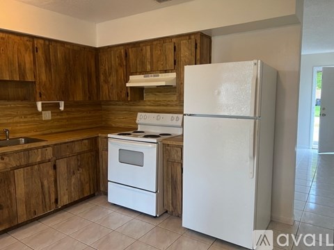 A kitchen with wooden cabinets and a white refrigerator.