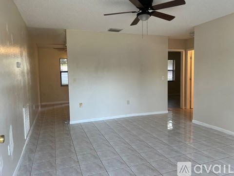 A spacious room with a ceiling fan and tile flooring.