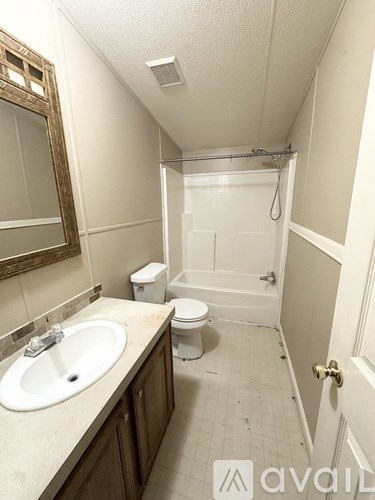 A bathroom with a toilet, sink, and shower.