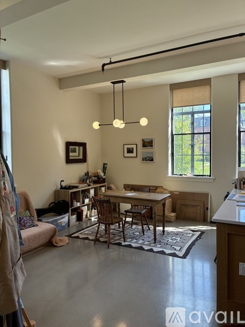 A living room with a dining table and chairs in the center.