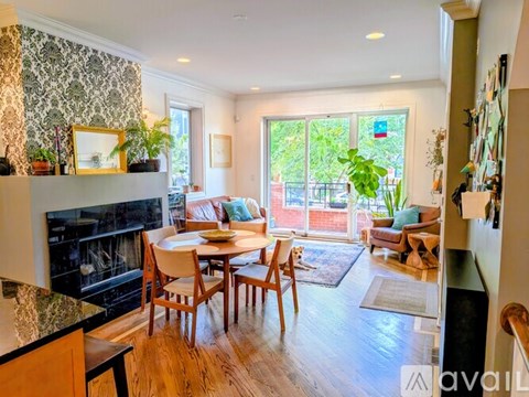 A living room with a fireplace and a dining table.