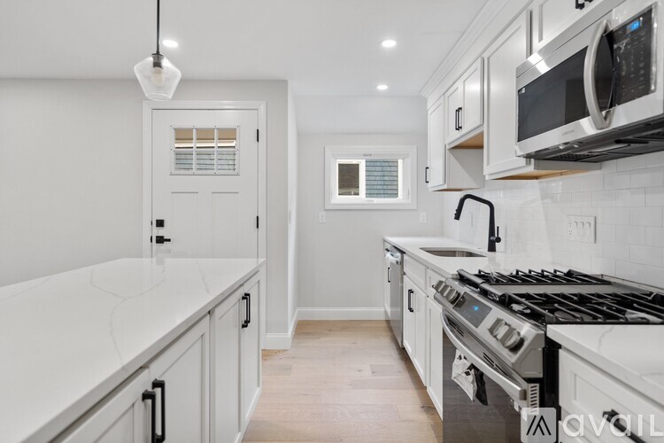 A kitchen with white cabinets and a black stove top.