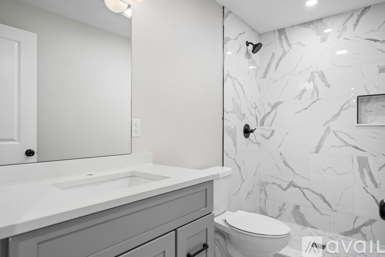 A bathroom with a marble wallpaper and a toilet.
