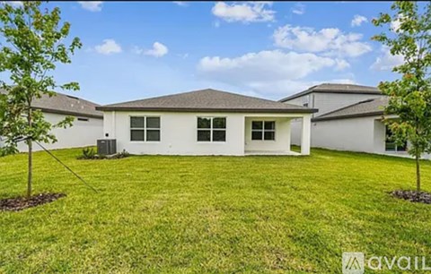 A house with a lawn and trees in front of it.