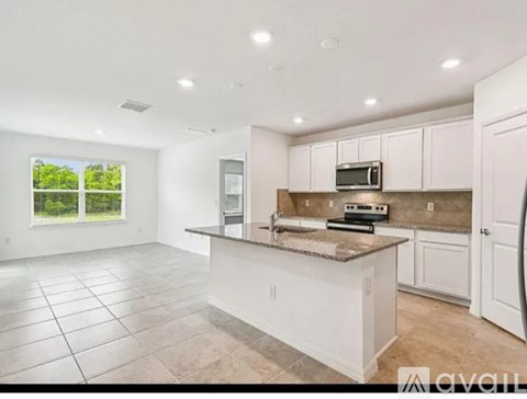 A kitchen with white cabinets and a granite countertop.
