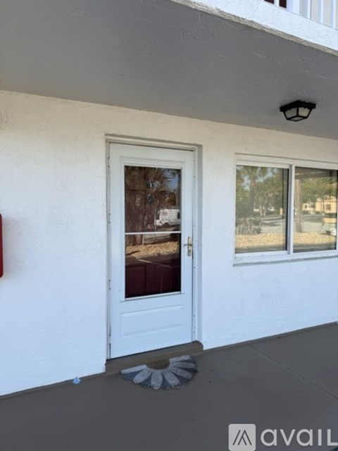 A white door with a glass window is on the front of a building.