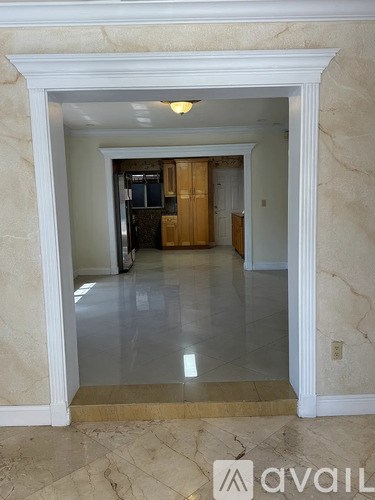 A hallway with a marble floor and white walls.