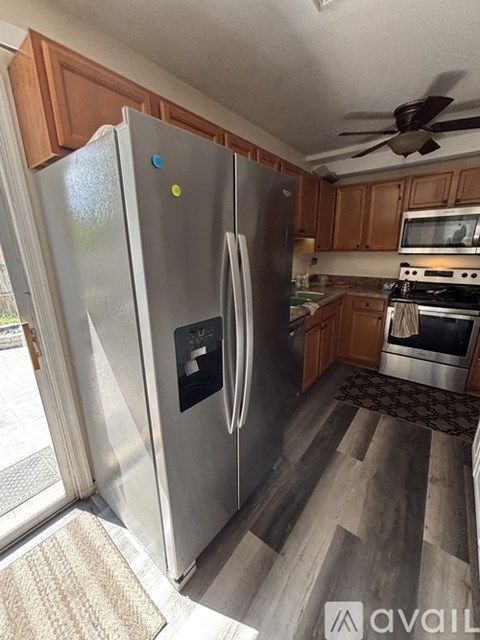 A modern kitchen with a stainless steel refrigerator and wooden cabinets.