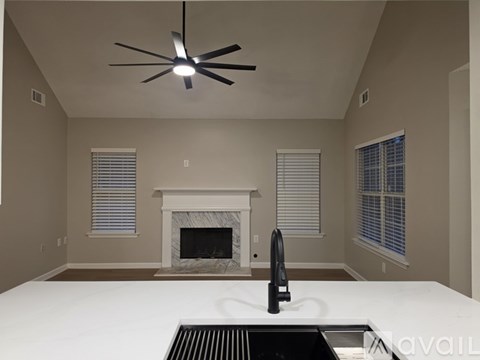 A modern kitchen with a white countertop and a black faucet.