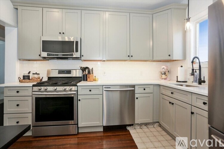 A kitchen with white cabinets and a stainless steel oven.