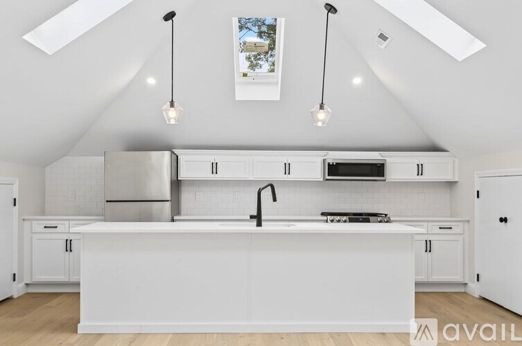 A modern kitchen with white cabinets and a large island.