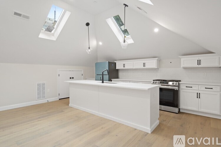 A kitchen with white cabinets and a large island.